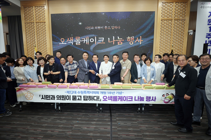 시민들과 수원특례시의회 의원들의 화합을 상징하는 오색롤케이크 나눔 행사를 하고 있다. 