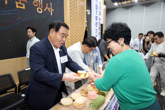 시민들과 수원특례시의회 의원들의 화합을 상징하는 오색롤케이크 나눔 행사를 하고 있다. 