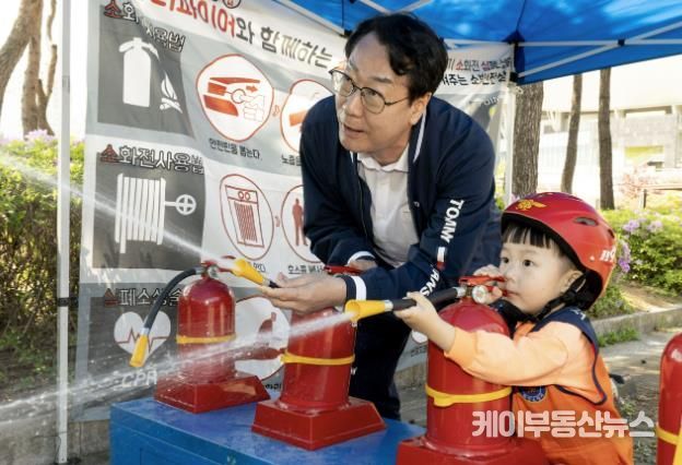 정명근 화성특례시장이 화성특례시 어린이날 영유아가족 어울림축제에서 어린이와 함께 소화기 사용 체험을 하고 있다.