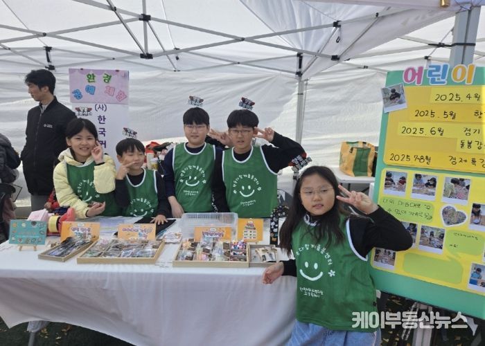 아동창업팀 수공예품 판매 부스에서 아이들이 포즈를 취하고 있다.