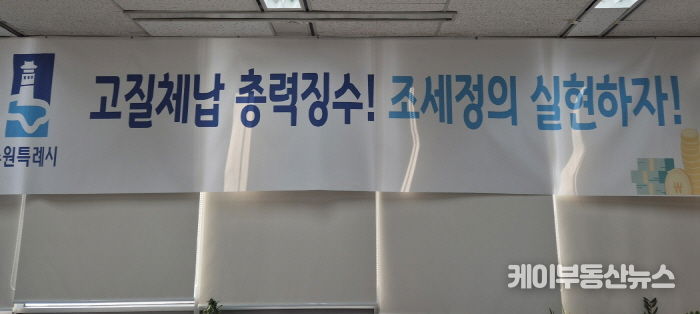 ‘고질체납 총력 징수! 조세정의 실현하자!’ 수원시 징수과 사무실에 걸려 있는 현수막.